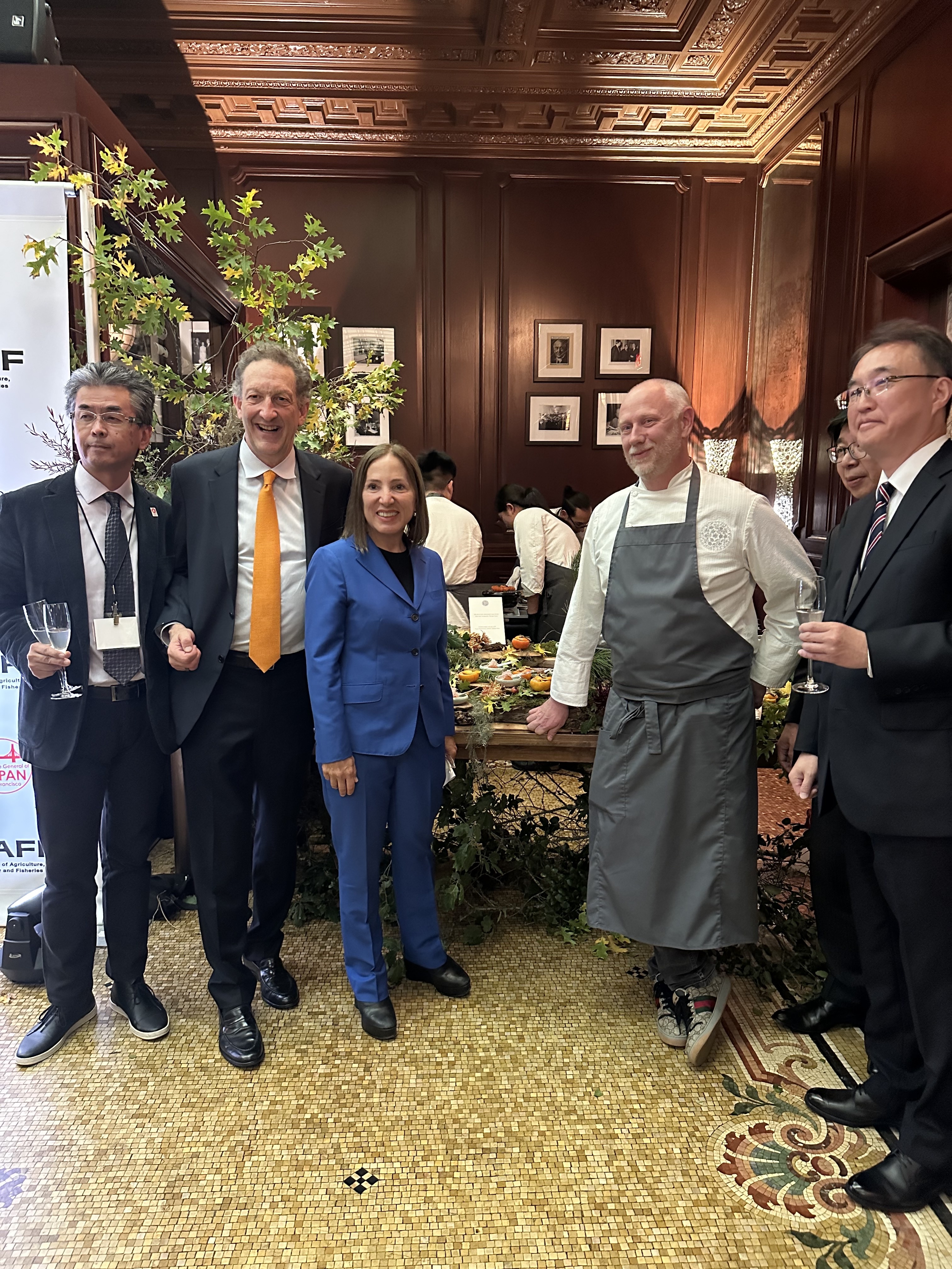 Image of Lt. Governor Kounalakis standing with a chef and other dignitaries at a reception. 